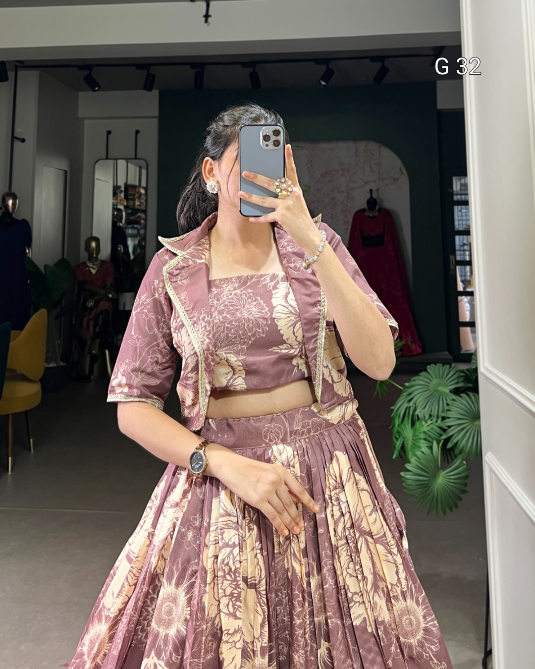 Person wearing a patterned outfit taking a mirror selfie in a store.