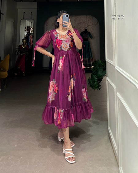 Person wearing a purple floral dress taking a mirror selfie in an indoor setting.