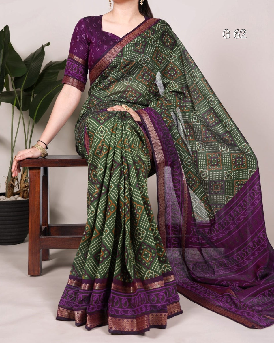 Woman wearing a green and purple saree with a plant in the background