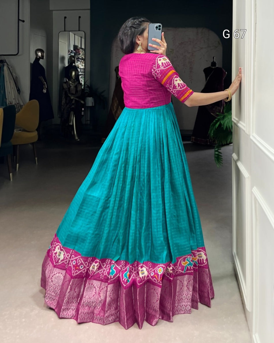Woman taking a mirror selfie wearing a pink blouse and teal skirt with floral patterns.