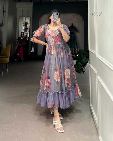 Woman wearing a floral dress taking a mirror selfie in an indoor setting.