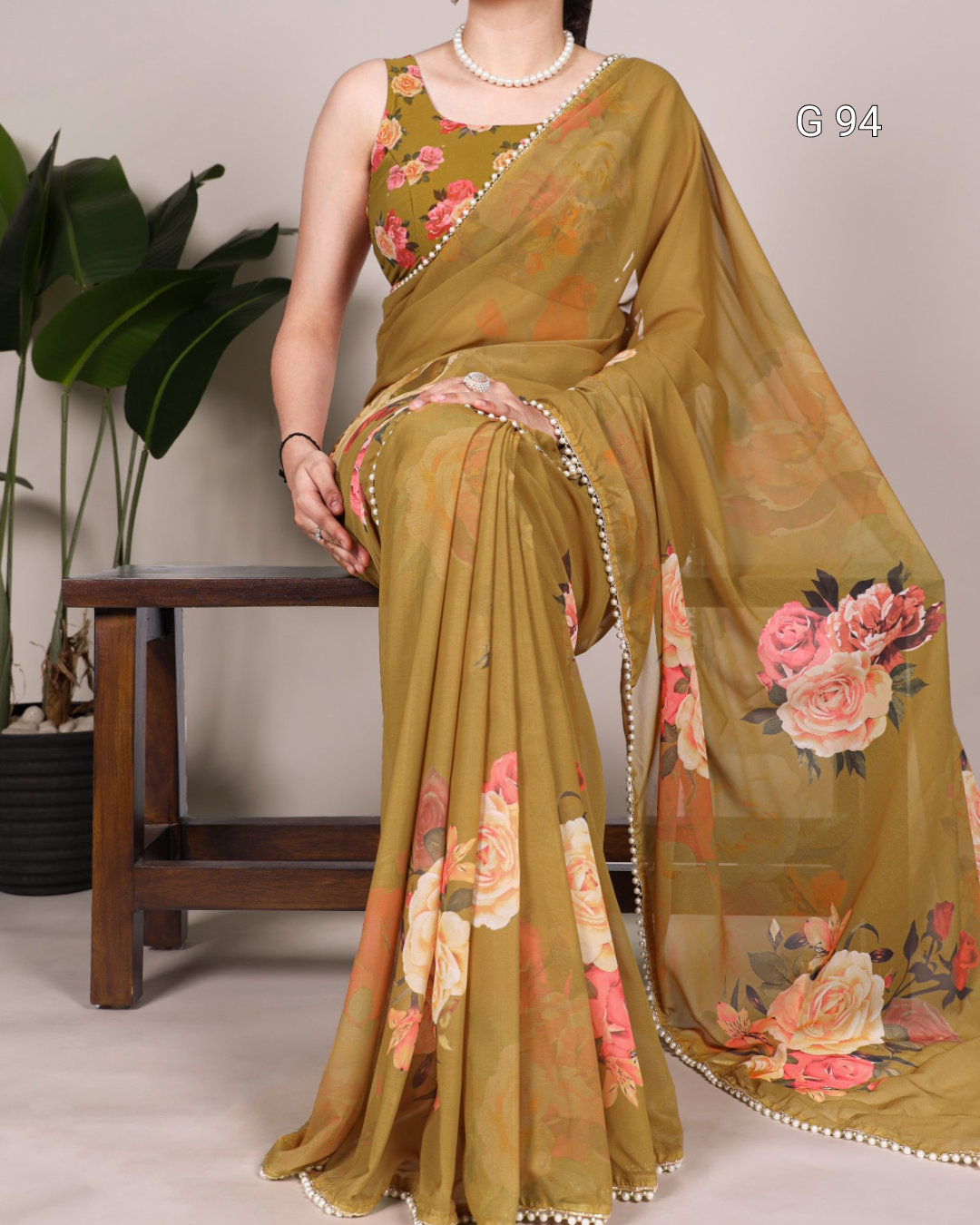 Woman wearing a floral saree with a plain background