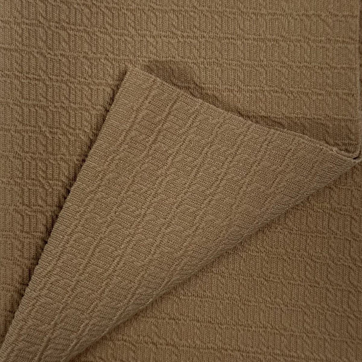 Close-up of brown textured fabric with a folded edge