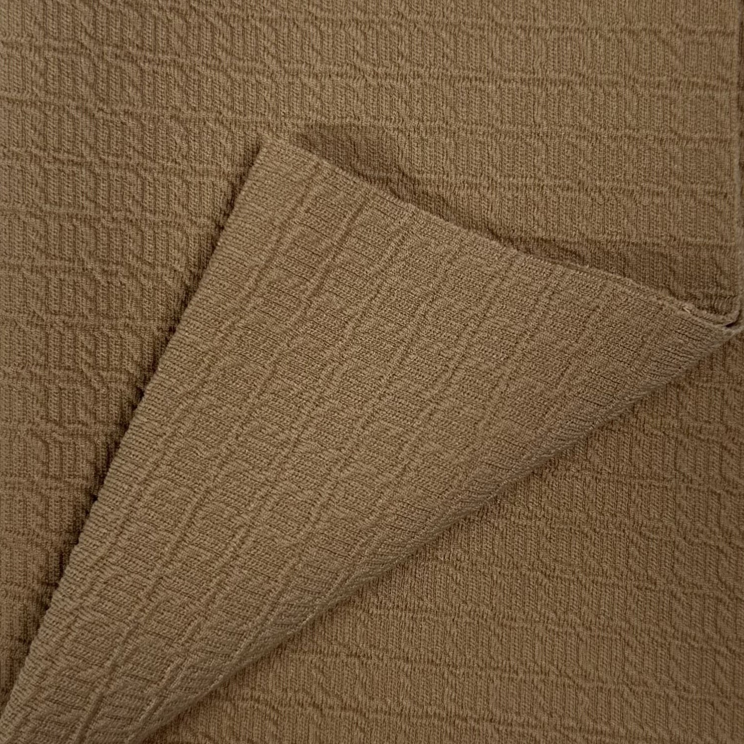Close-up of brown textured fabric with a folded edge