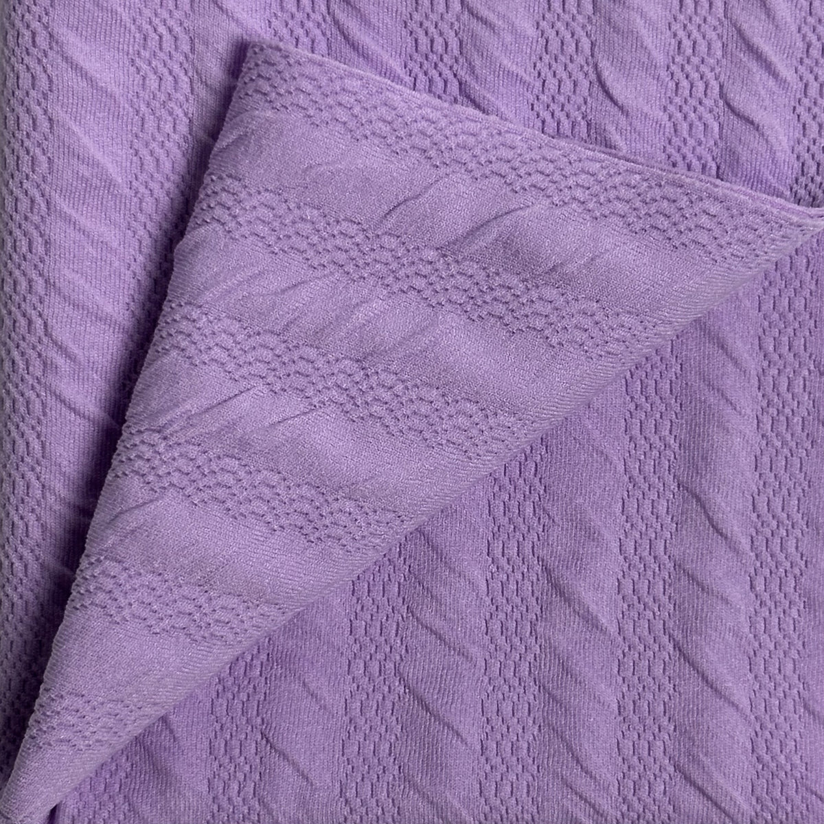 Close-up of textured purple fabric with a soft pattern