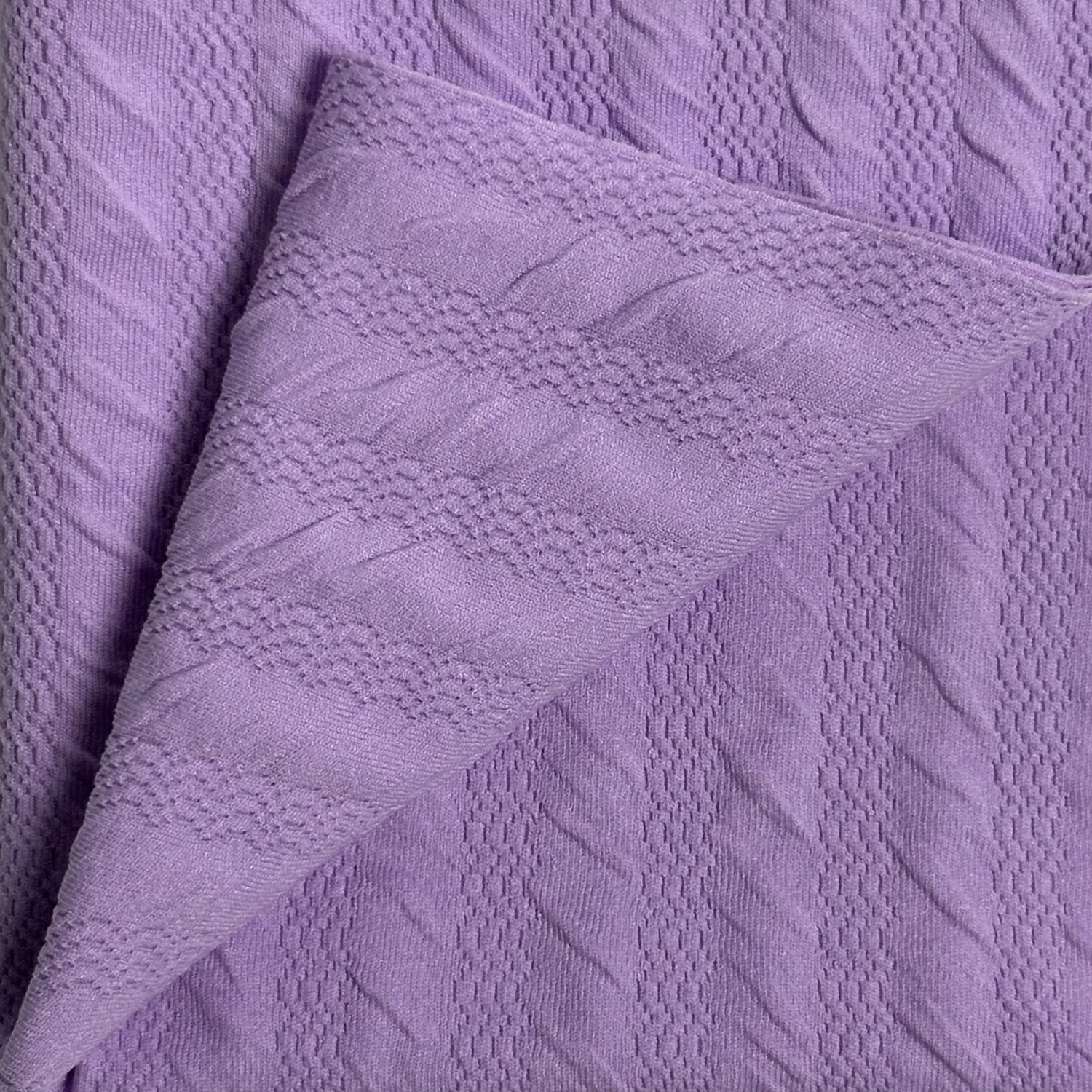 Close-up of textured purple fabric with a soft pattern