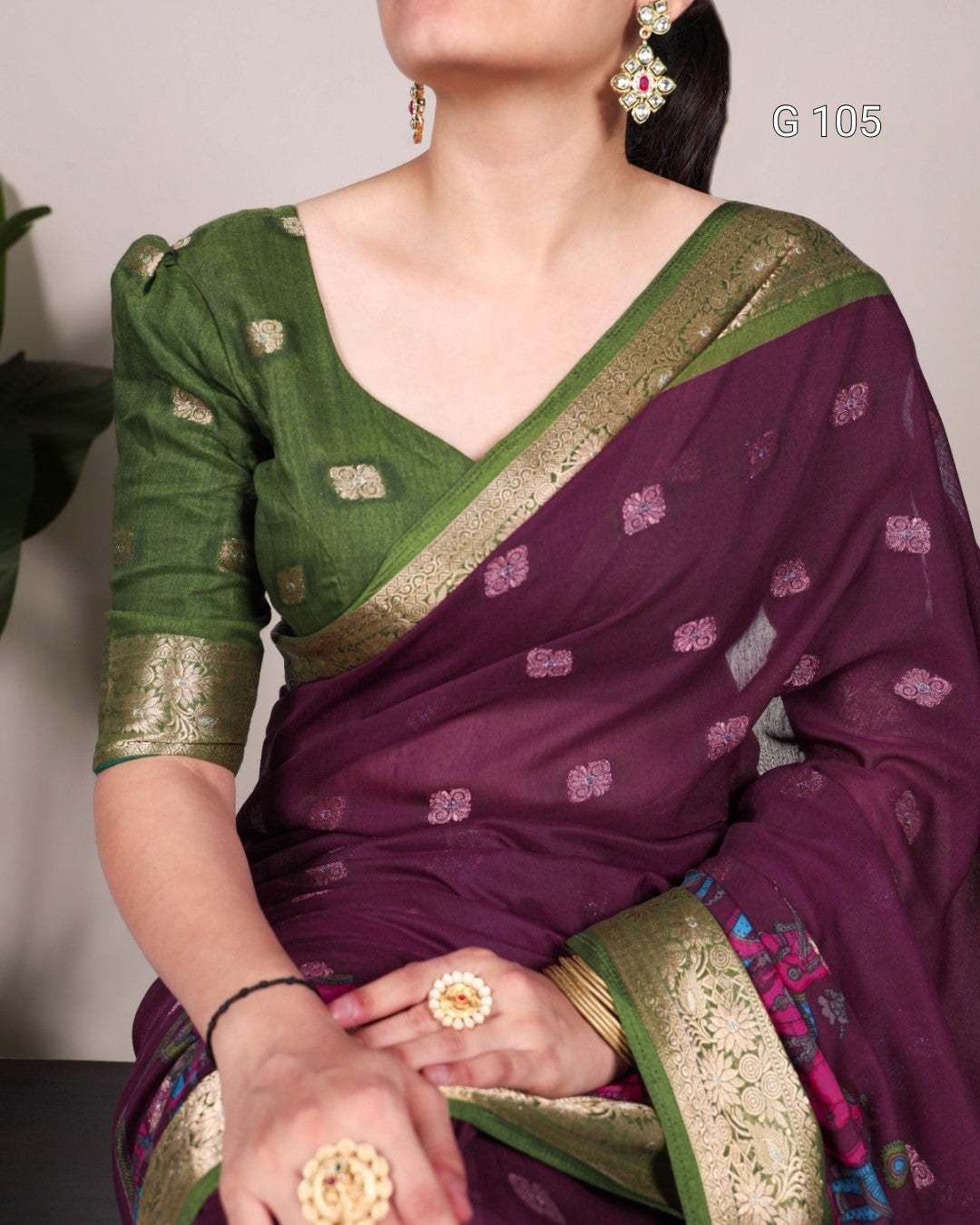 Woman wearing a green and purple saree with gold border