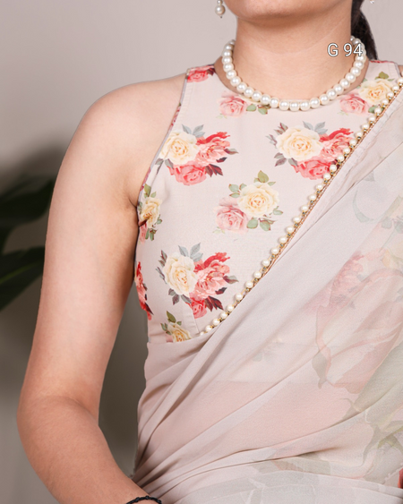 Woman wearing a floral saree with a pearl necklace against a neutral background