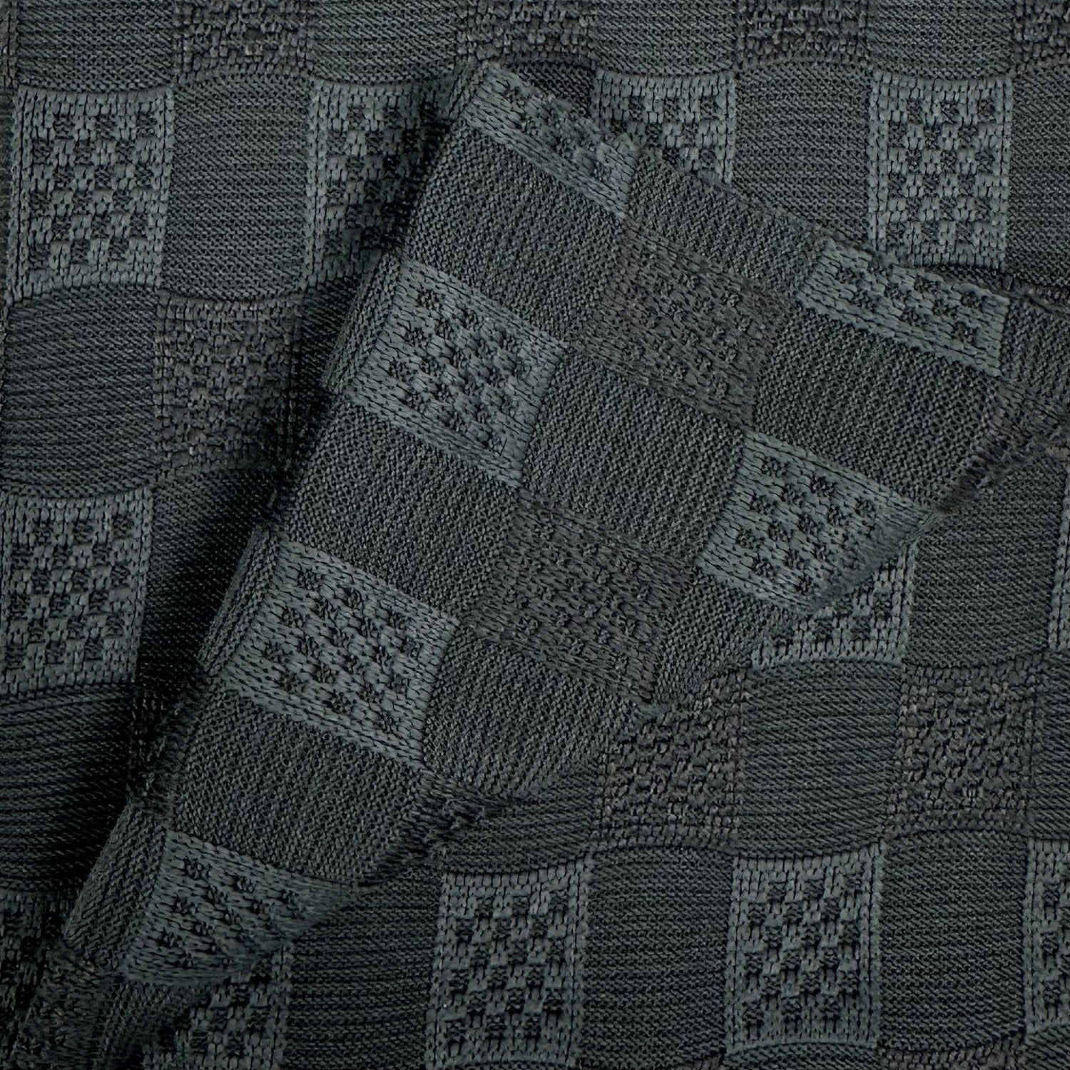 Close-up of a dark gray knitted fabric with a geometric pattern