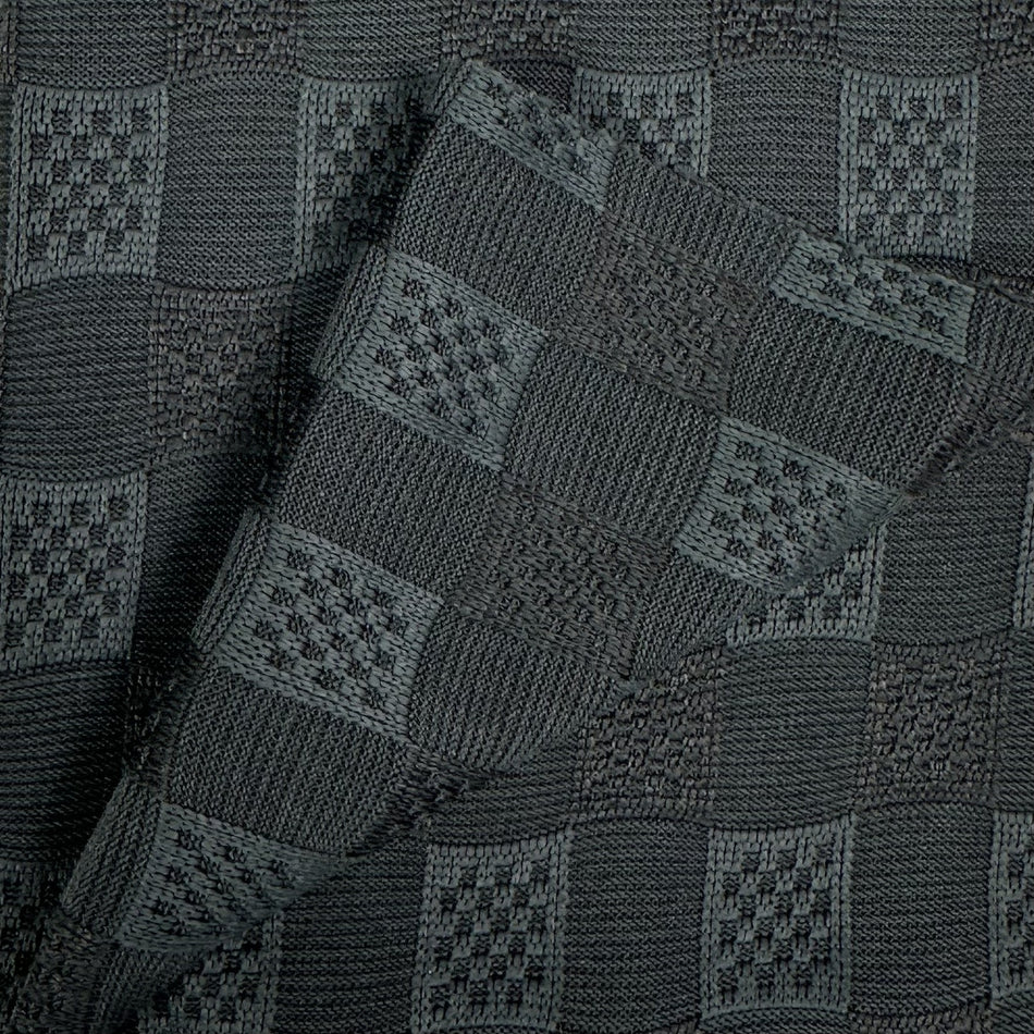 Close-up of a dark gray knitted fabric with a geometric pattern