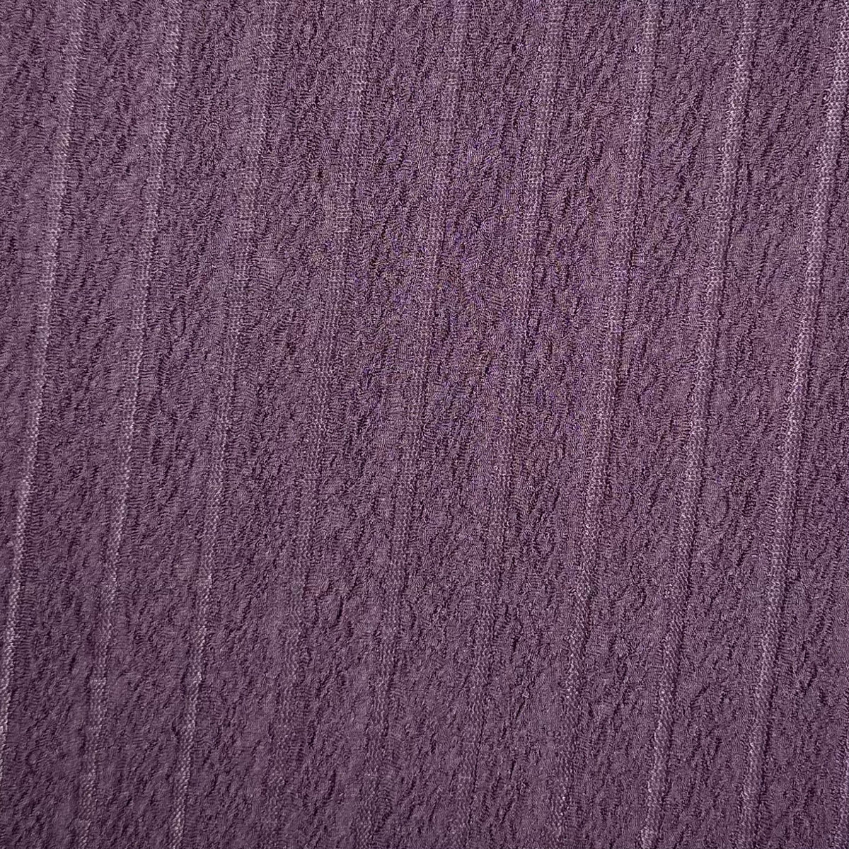 Close-up of textured purple fabric with a subtle pattern