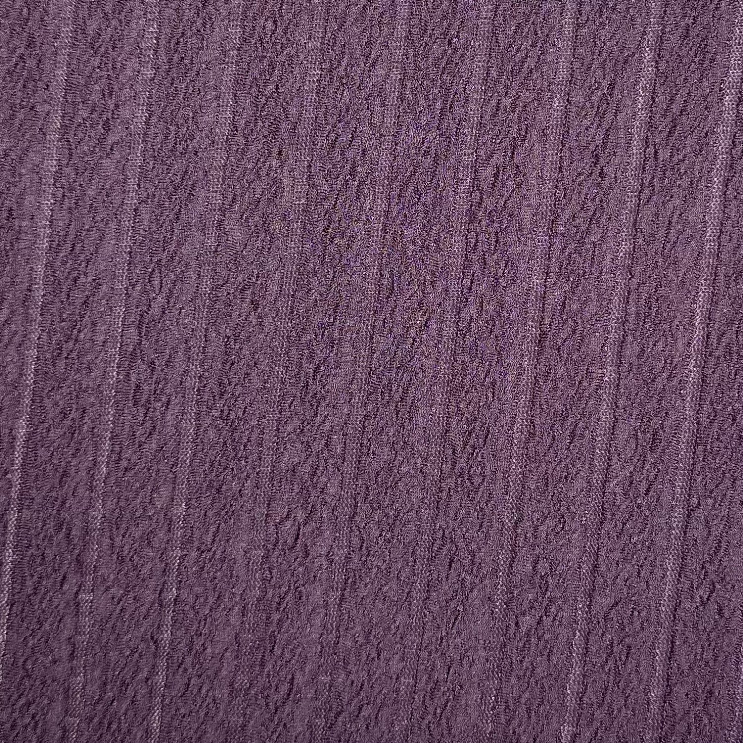 Close-up of textured purple fabric with a subtle pattern