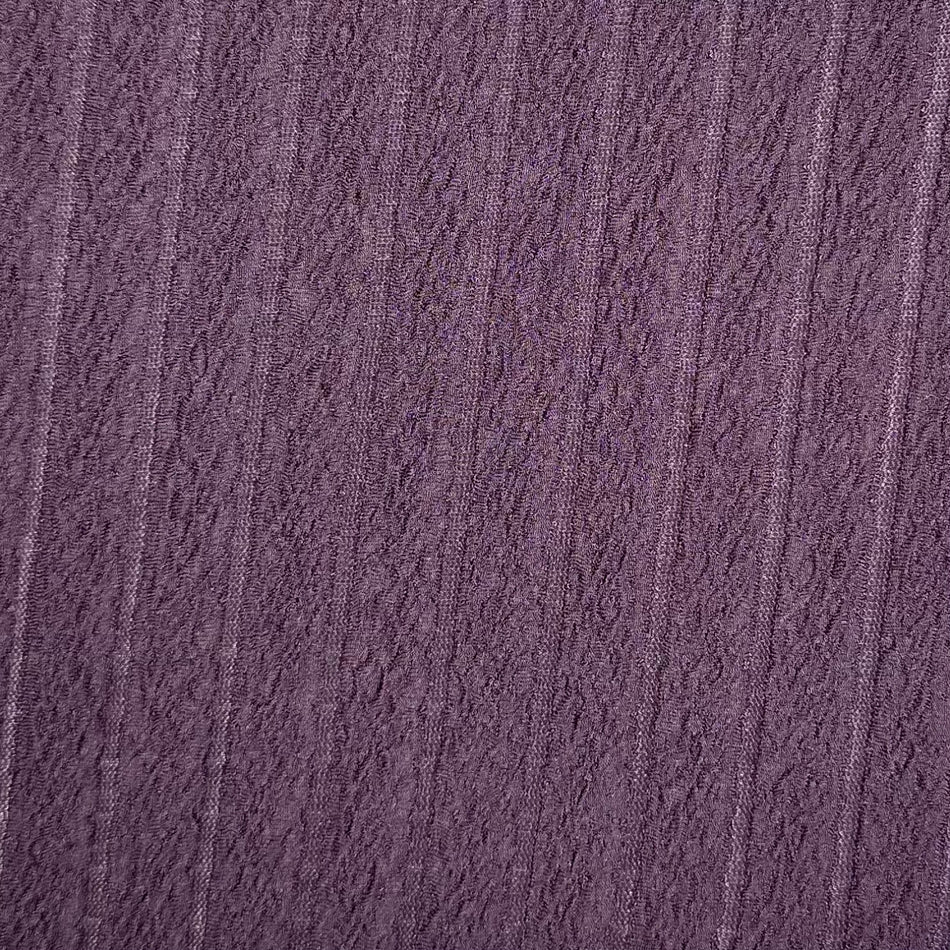 Close-up of textured purple fabric with a subtle pattern