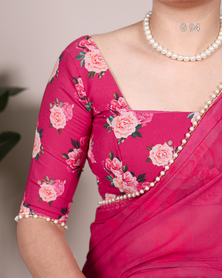 Close-up of a pink saree with floral patterns and pearl border on a neutral background