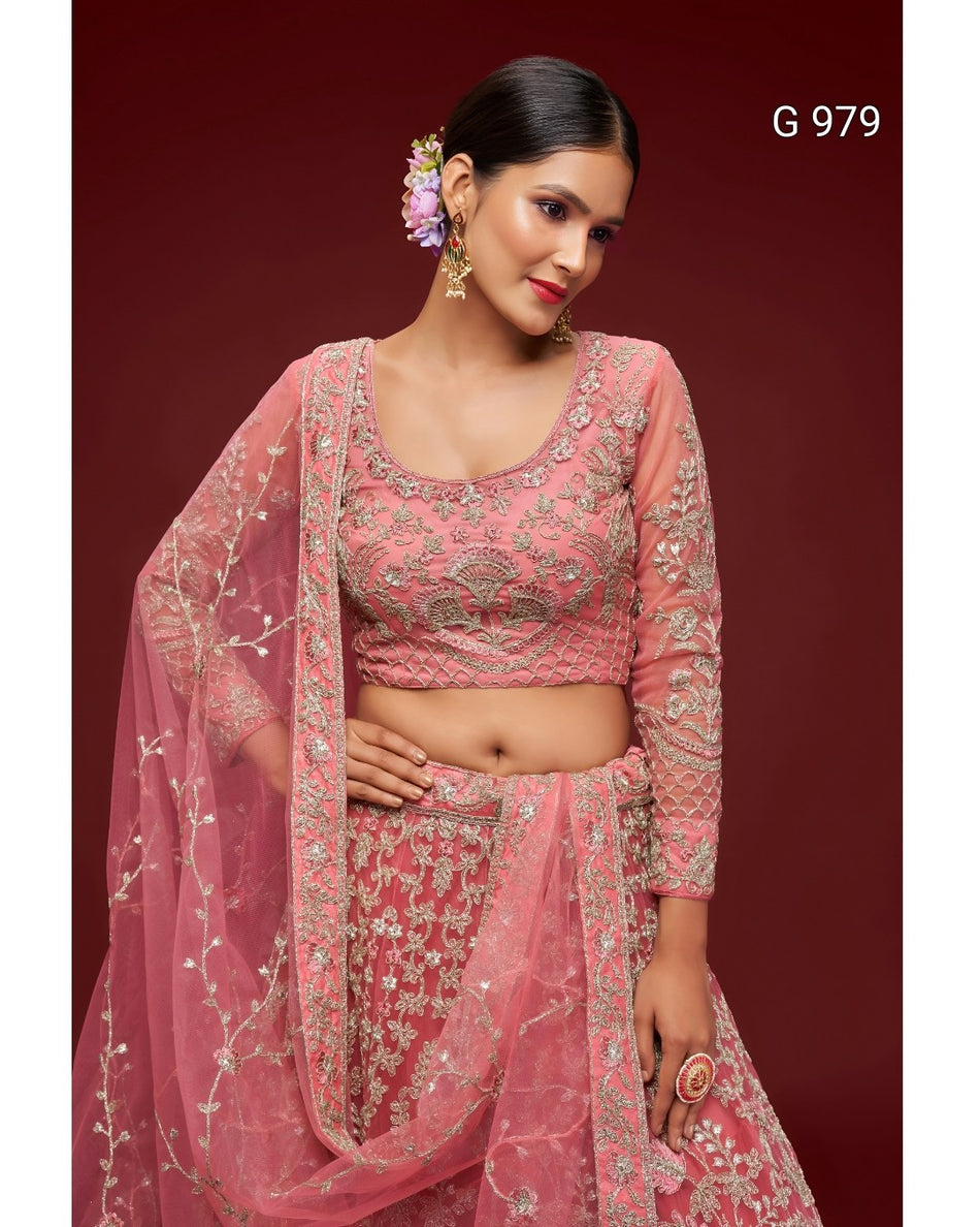 A woman modeling a pink embroidered traditional outfit with a matching sheer dupatta, set against a dark red studio background. The outfit features intricate floral embroidery and beadwork, and the text 'G 979' appears in the top right corner.