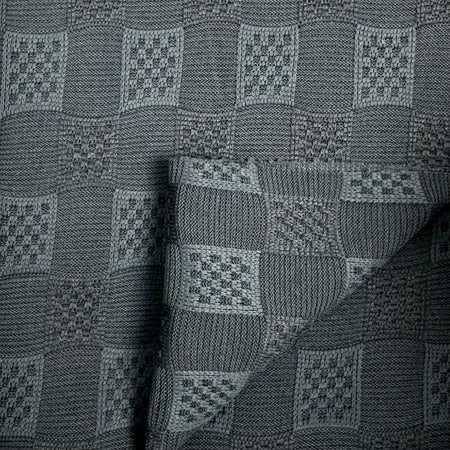 Textured fabric with a geometric pattern in shades of gray.