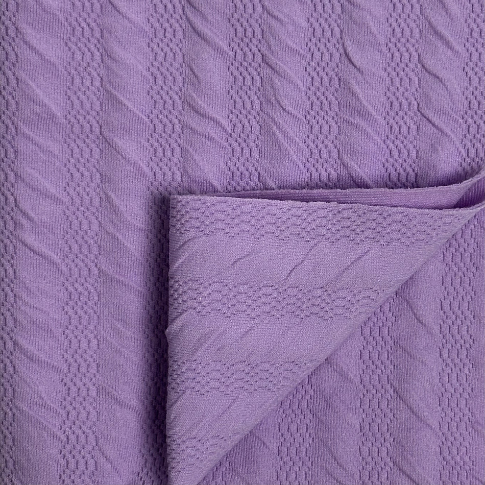 Close-up of textured purple fabric with a folded corner