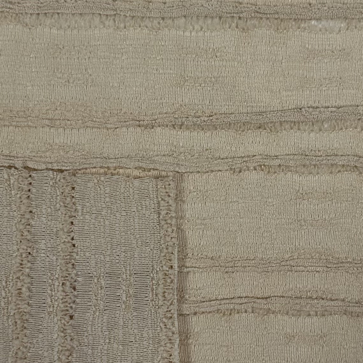 Close-up of a textured beige fabric with a subtle pattern