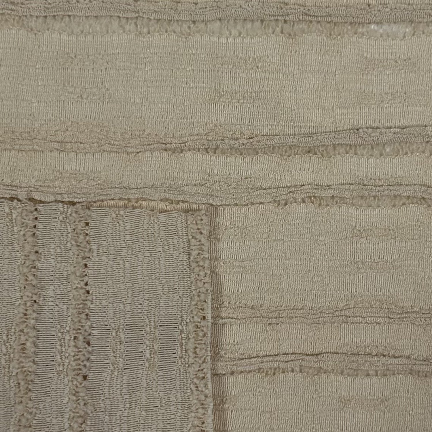 Close-up of a textured beige fabric with a subtle pattern