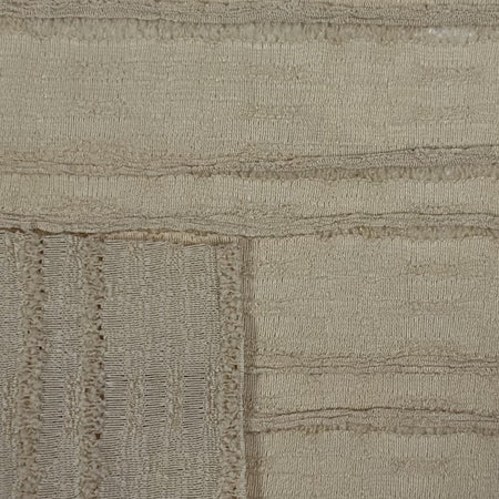Close-up of a textured beige fabric with a subtle pattern