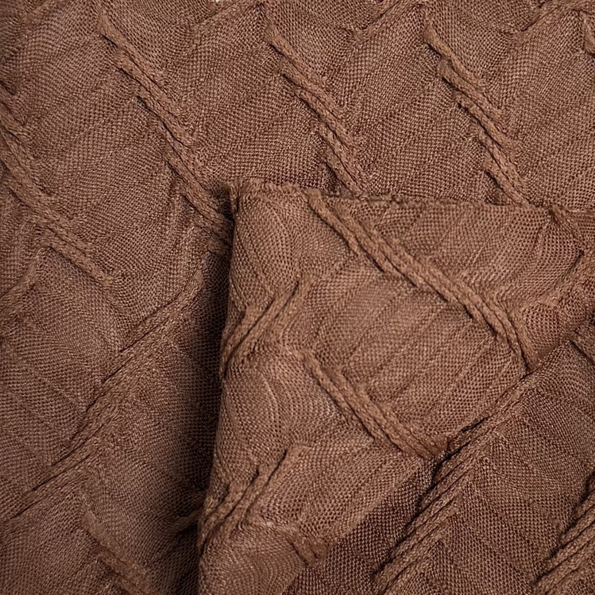 Close-up of brown textured fabric with a diamond pattern