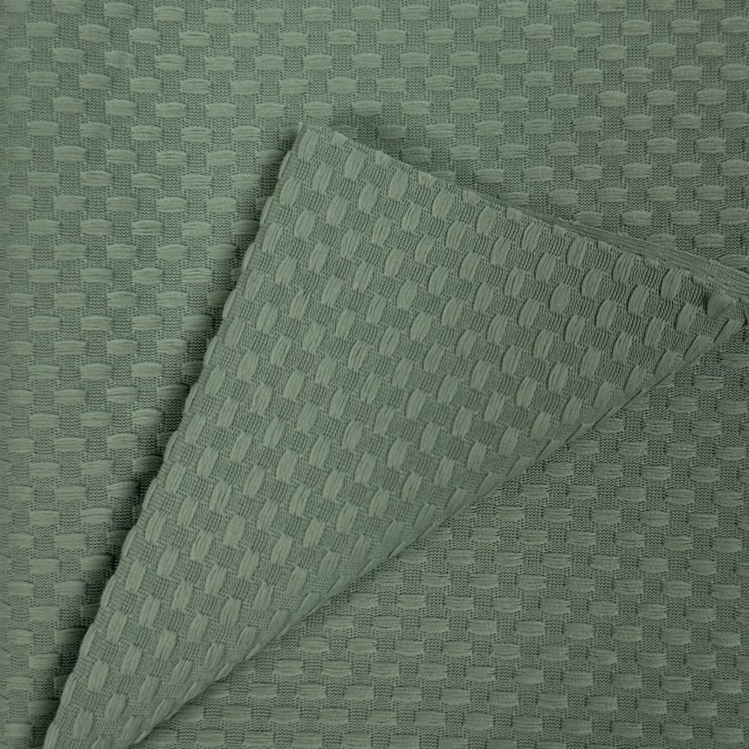 Textured green fabric with a subtle pattern on a matching background