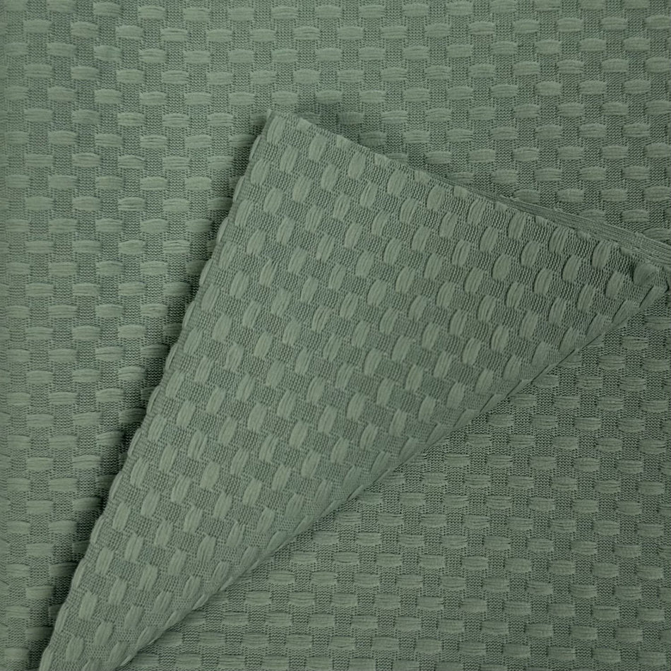 Textured green fabric with a subtle pattern on a matching background