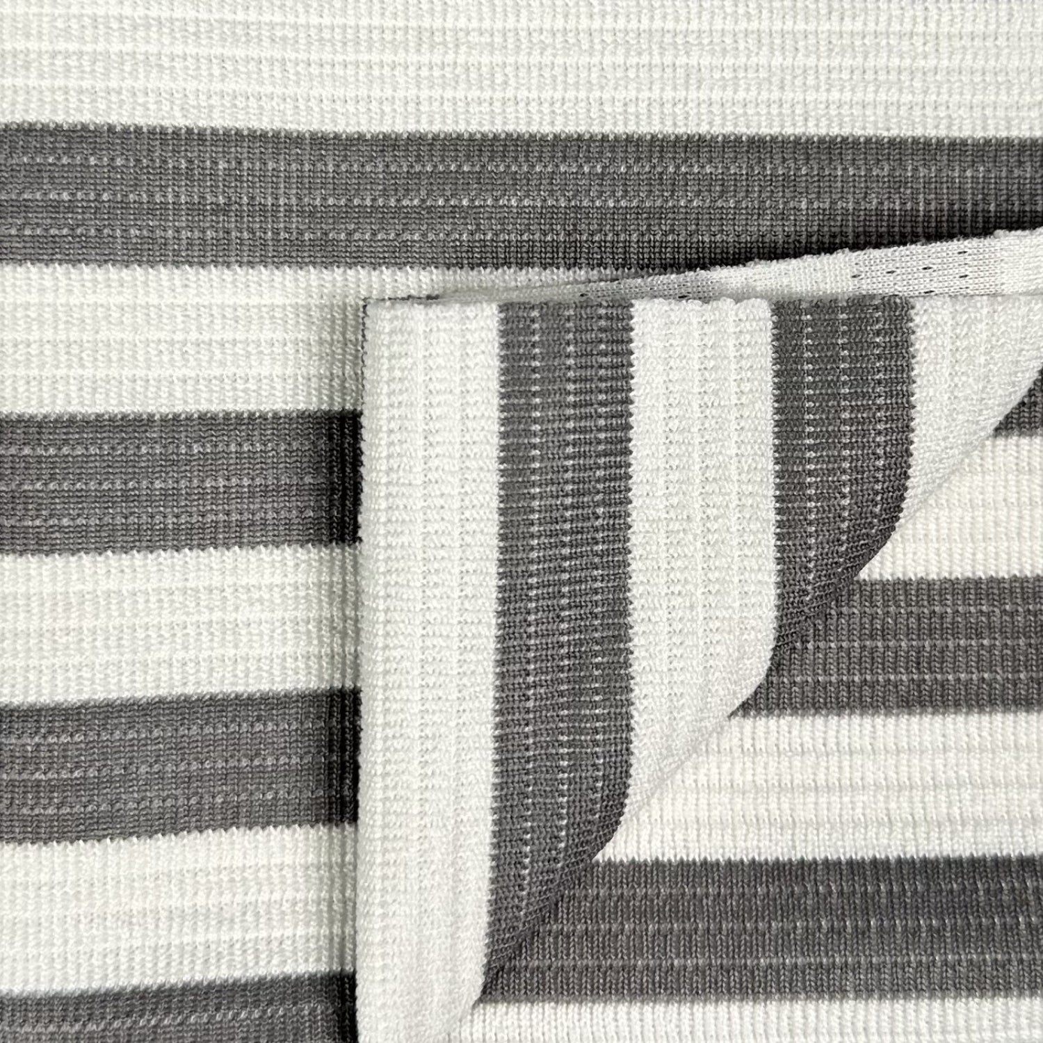 Close-up of a gray and white striped fabric with a visible seam.
