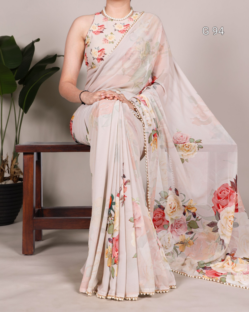 Woman wearing a floral saree sitting on a chair with a neutral background