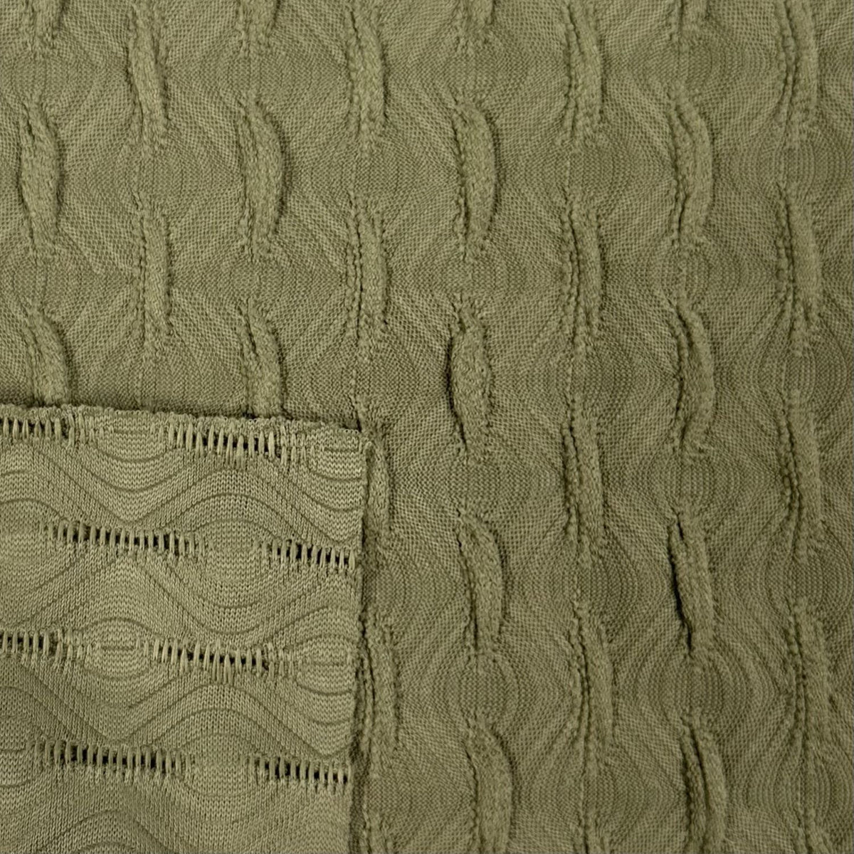 Close-up of textured green fabric with a patterned edge.