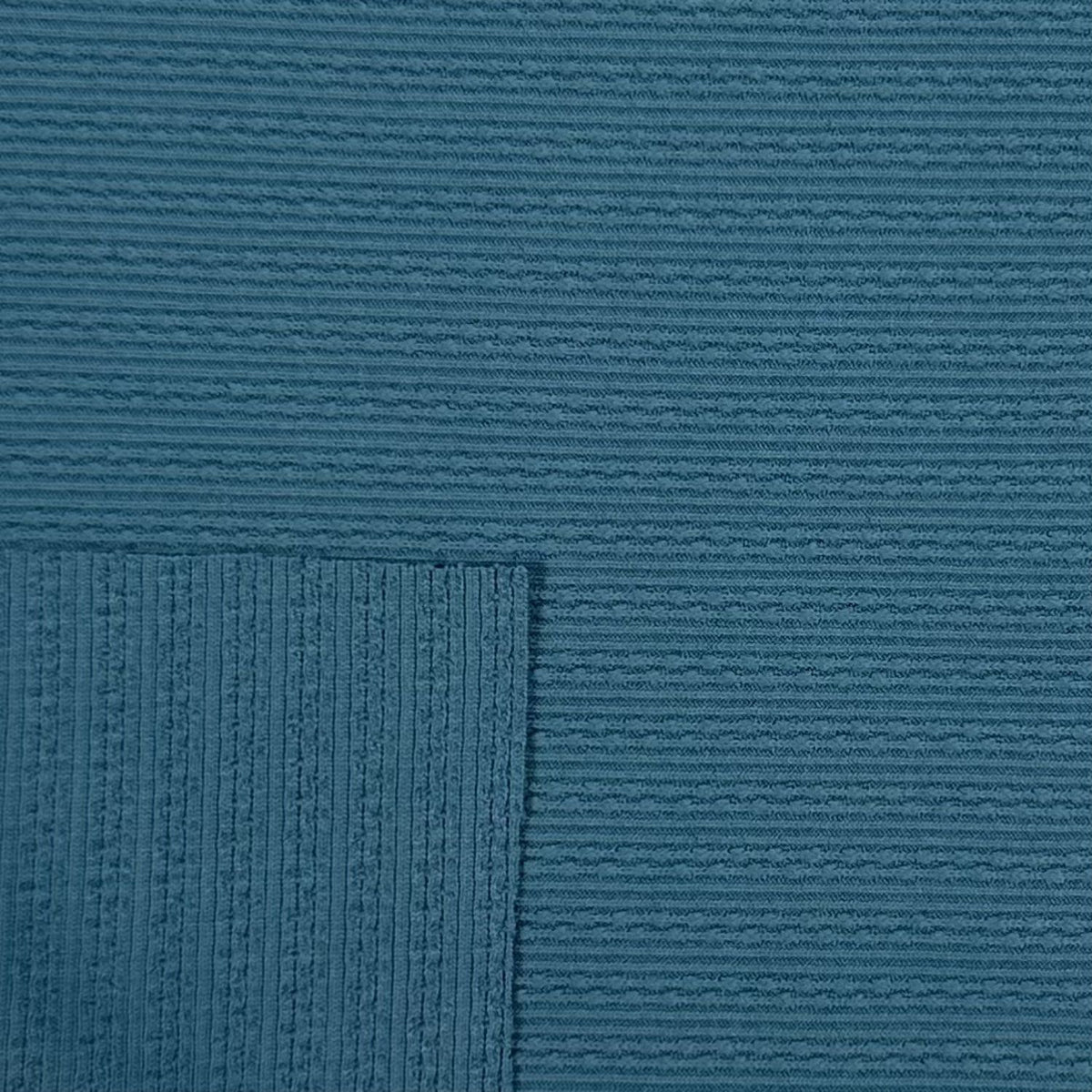 Close-up of textured blue fabric with a subtle pattern