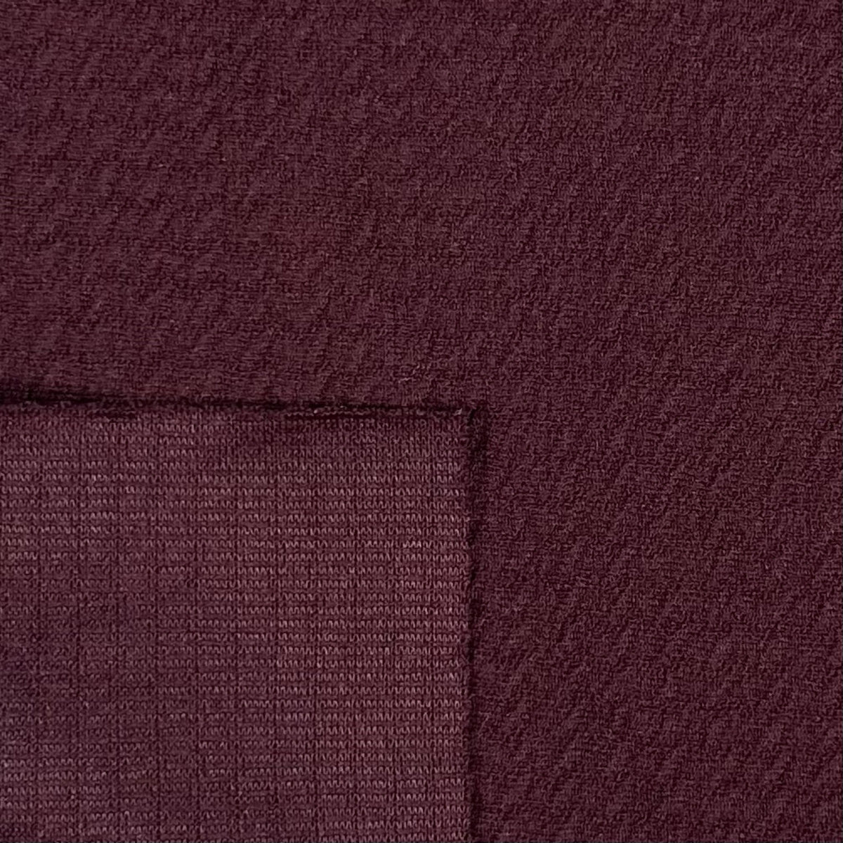 Close-up of maroon fabric with a subtle pattern