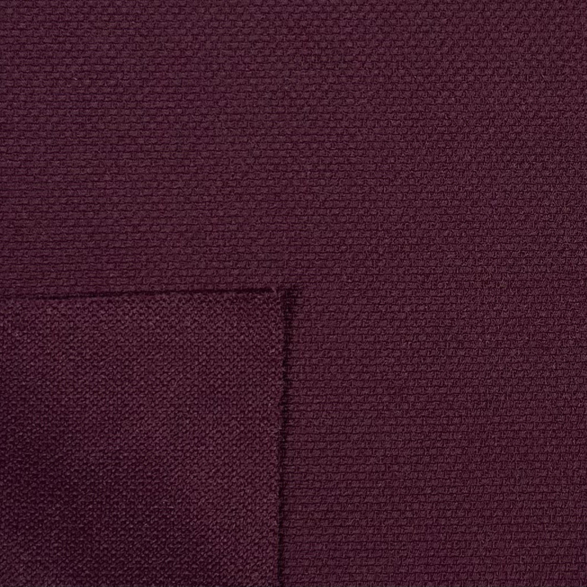 Close-up of a textured purple fabric with a pocket detail