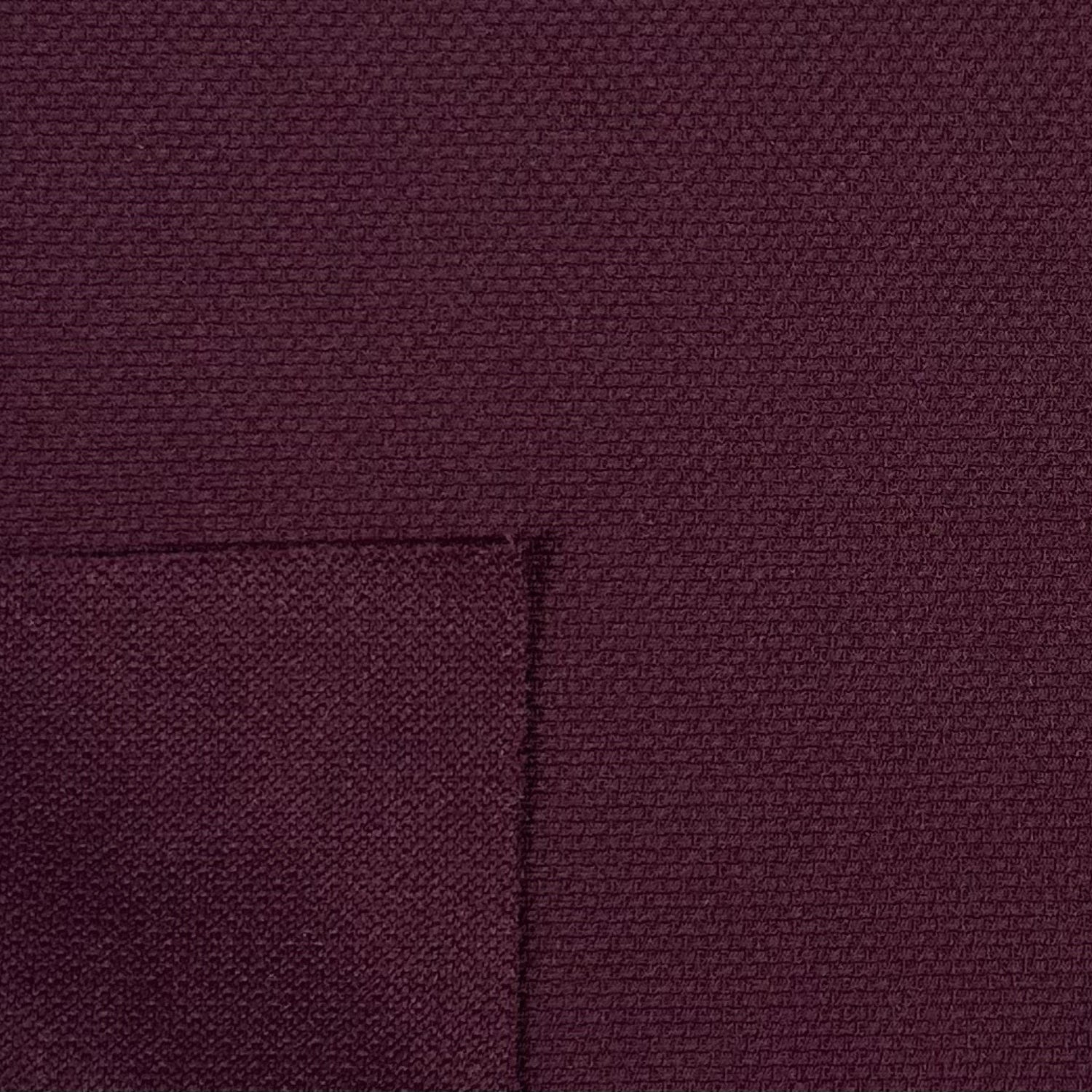 Close-up of a textured purple fabric with a pocket detail