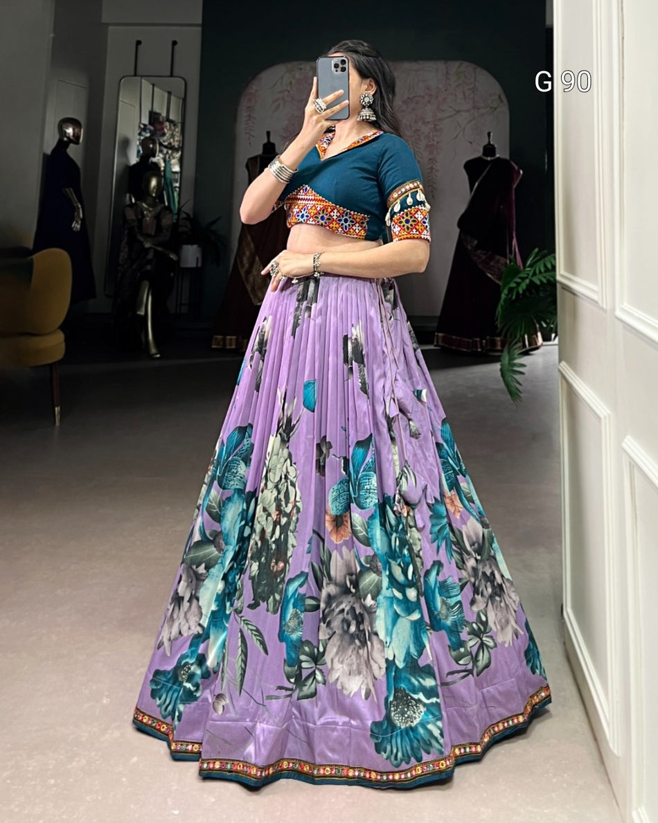 Woman taking a mirror selfie wearing a traditional outfit with a purple skirt and blue top.