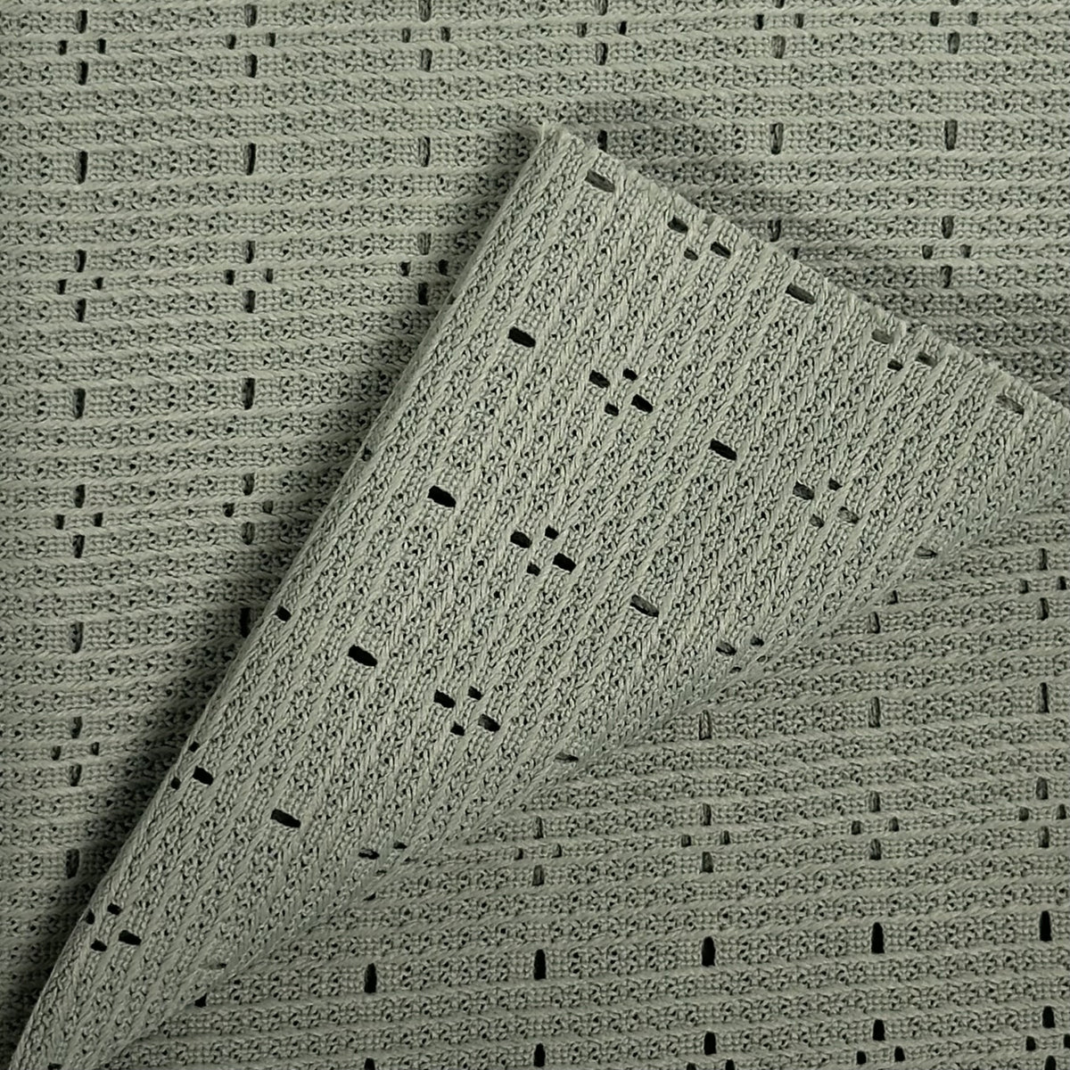 Textured green fabric with a subtle pattern on a matching background