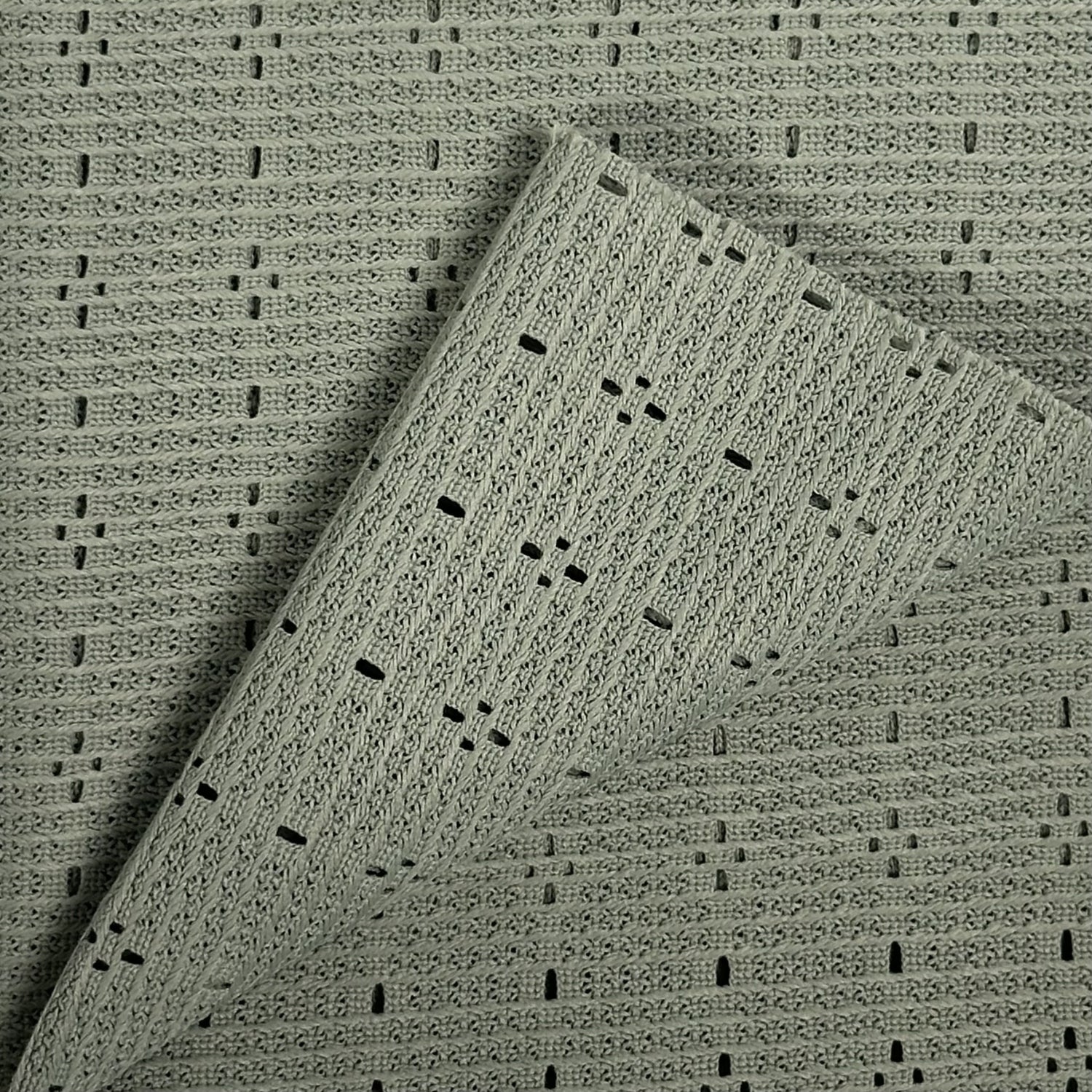 Textured green fabric with a subtle pattern on a matching background