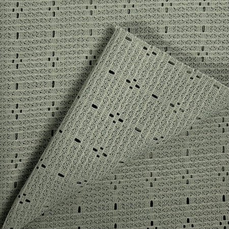 Textured green fabric with a subtle pattern on a matching background