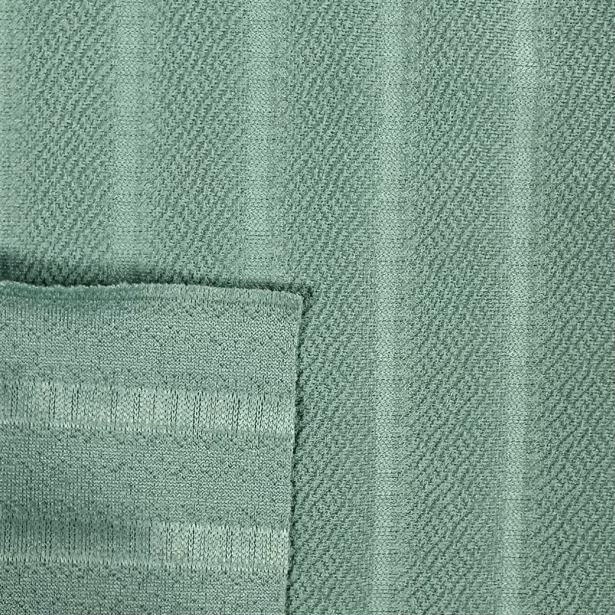 Close-up of a textured green fabric with a subtle pattern