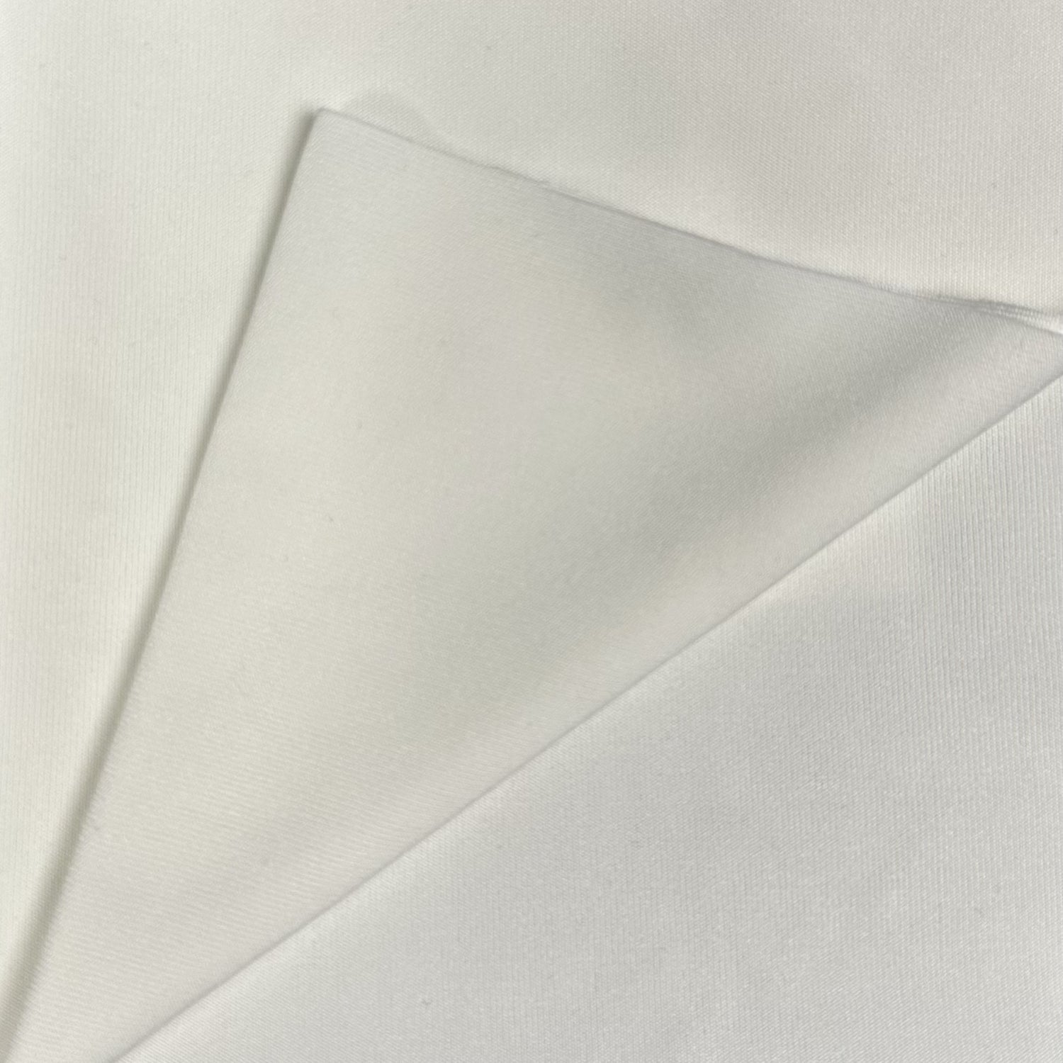 Close-up of a light gray fabric with a subtle texture on a white background