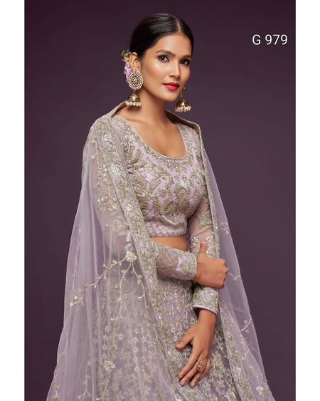 A woman modeling a lavender and silver embroidered traditional outfit with a sheer draped overlay, set against a solid dark purple background. The text 'G 979' is visible in the top right corner.