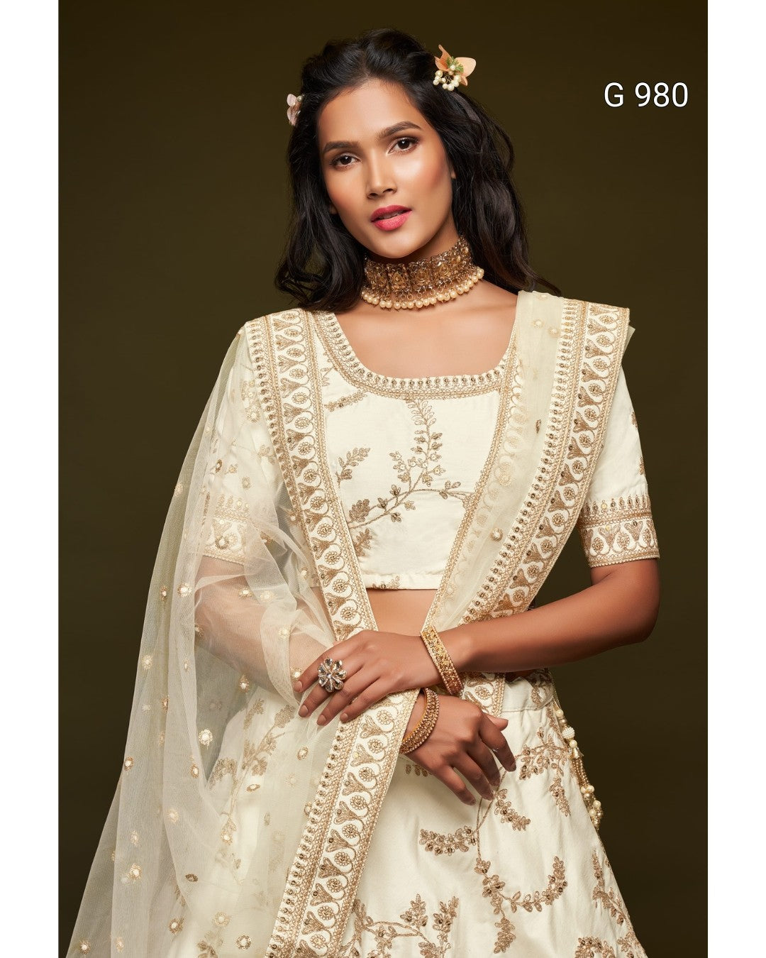 A woman modeling a cream and gold embroidered Indian ethnic outfit with a matching sheer dupatta, set against a dark brown studio background. The text 'G 980' is visible in the top right corner.