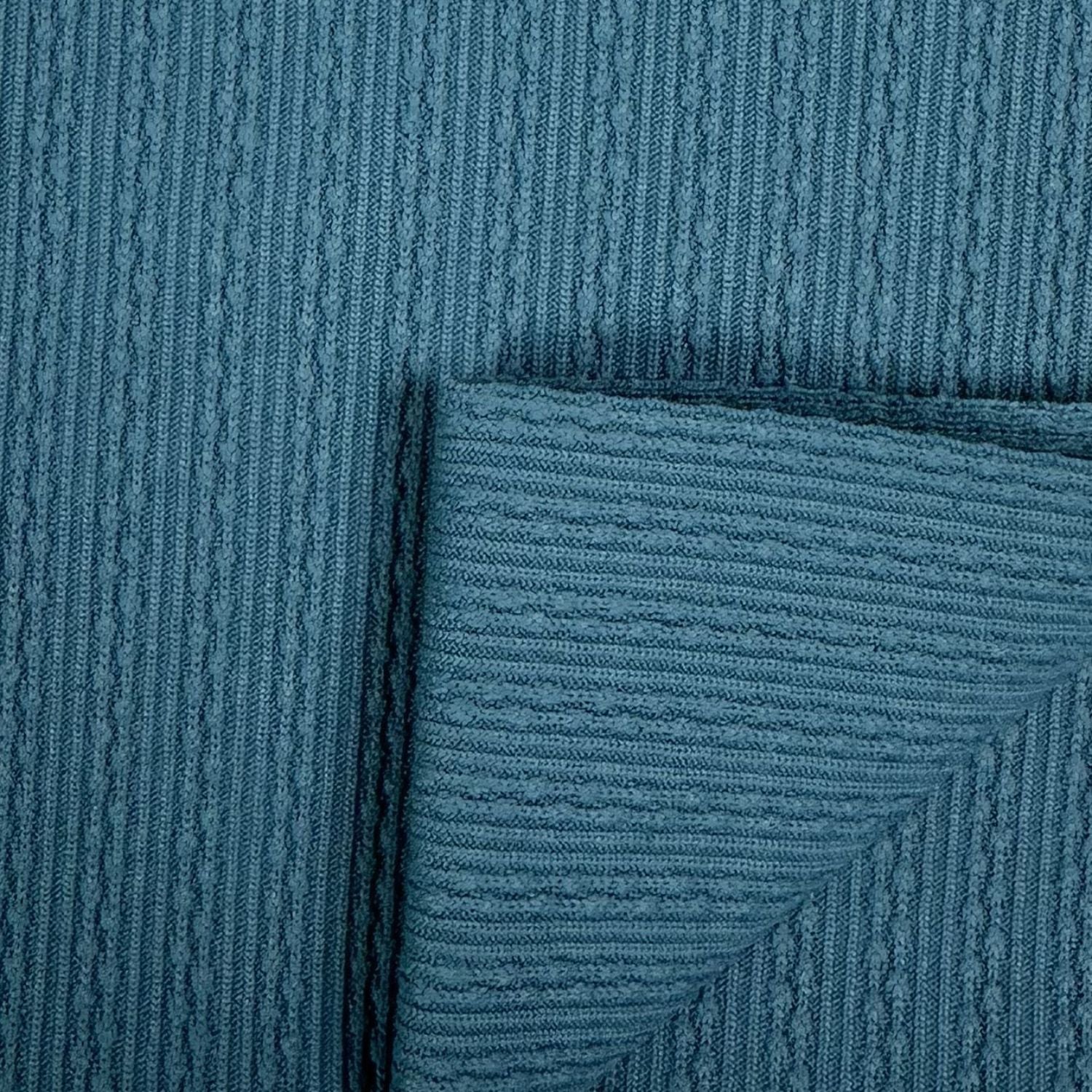 Close-up of textured teal fabric with a subtle pattern