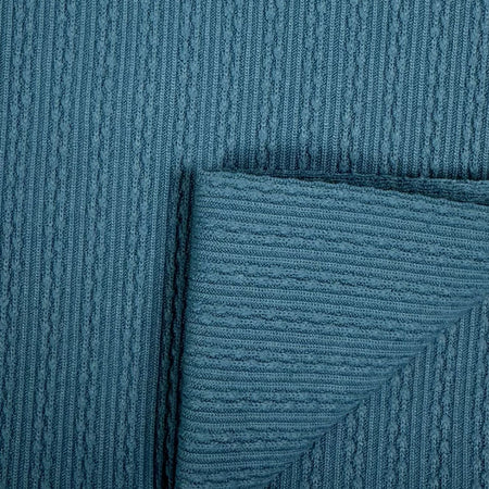 Close-up of textured teal fabric with a subtle pattern