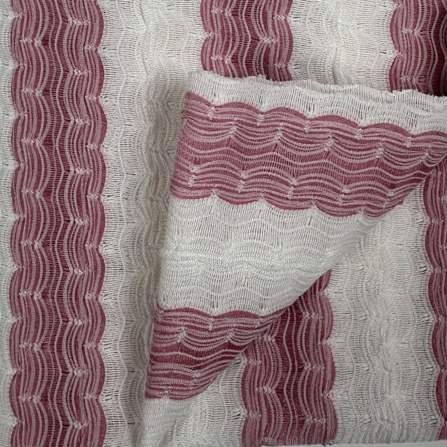 Close-up of fabric with red wavy pattern on a white background