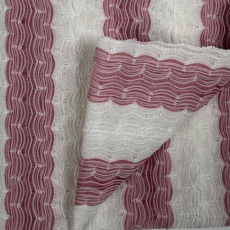 Close-up of fabric with red wavy pattern on a white background