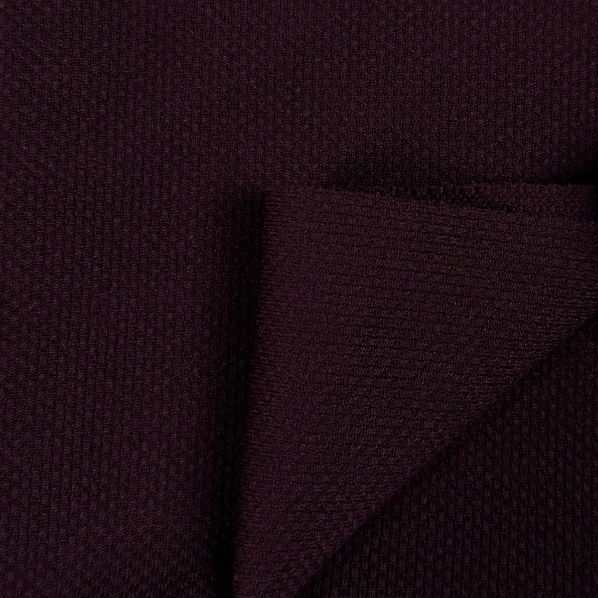 Close-up of dark purple fabric with a textured pattern