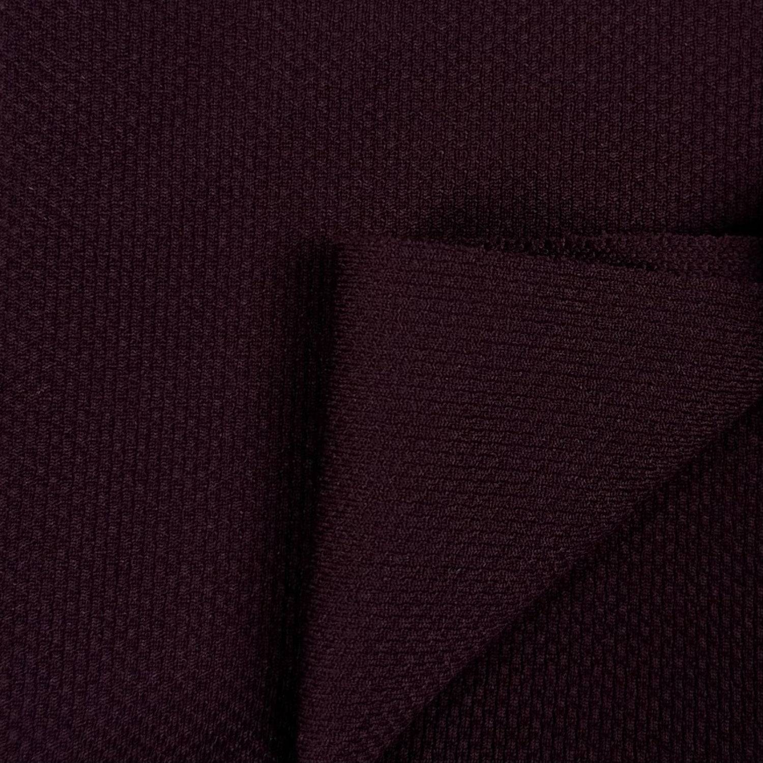 Close-up of dark purple fabric with a textured pattern