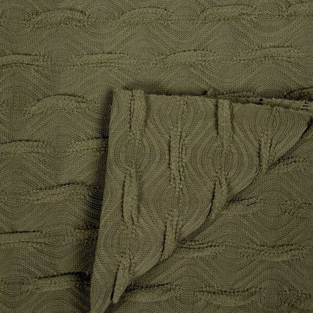 Close-up of textured green fabric with a patterned design.