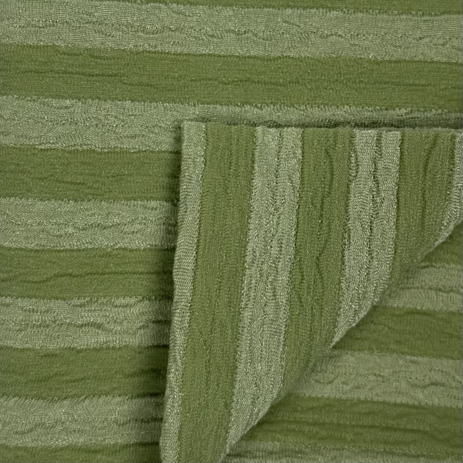 Close-up of green textured fabric with a folded edge